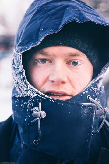 Portrait of person in winter jacket with frost on hood and face