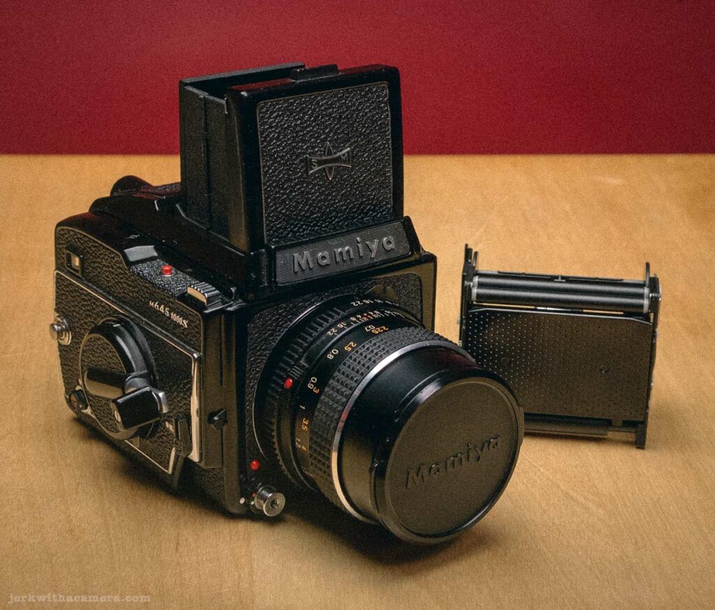 Mamiya medium format camera with detached film back on wooden surface