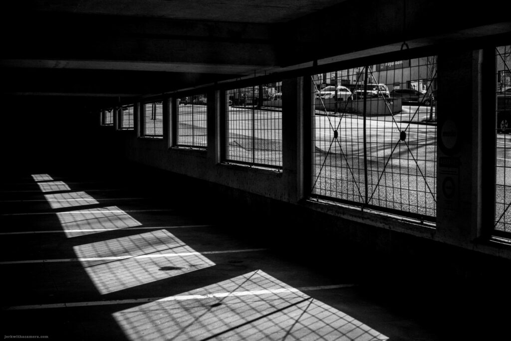 Shadows of window grates on the floor in an empty parking garage