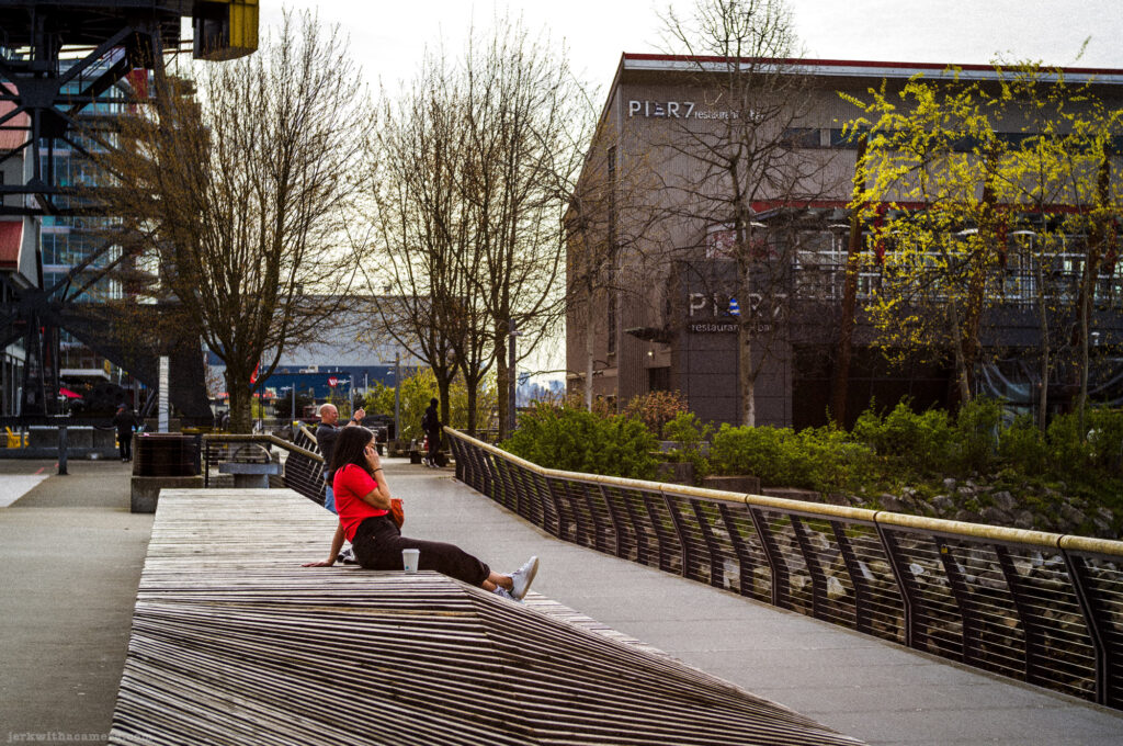 People sitting on wooden benches outside Pier 7, photographed with a Leica M-D Typ 262 and the Light Lens Lab 50mm f/1.2 ASPH "1966” lens