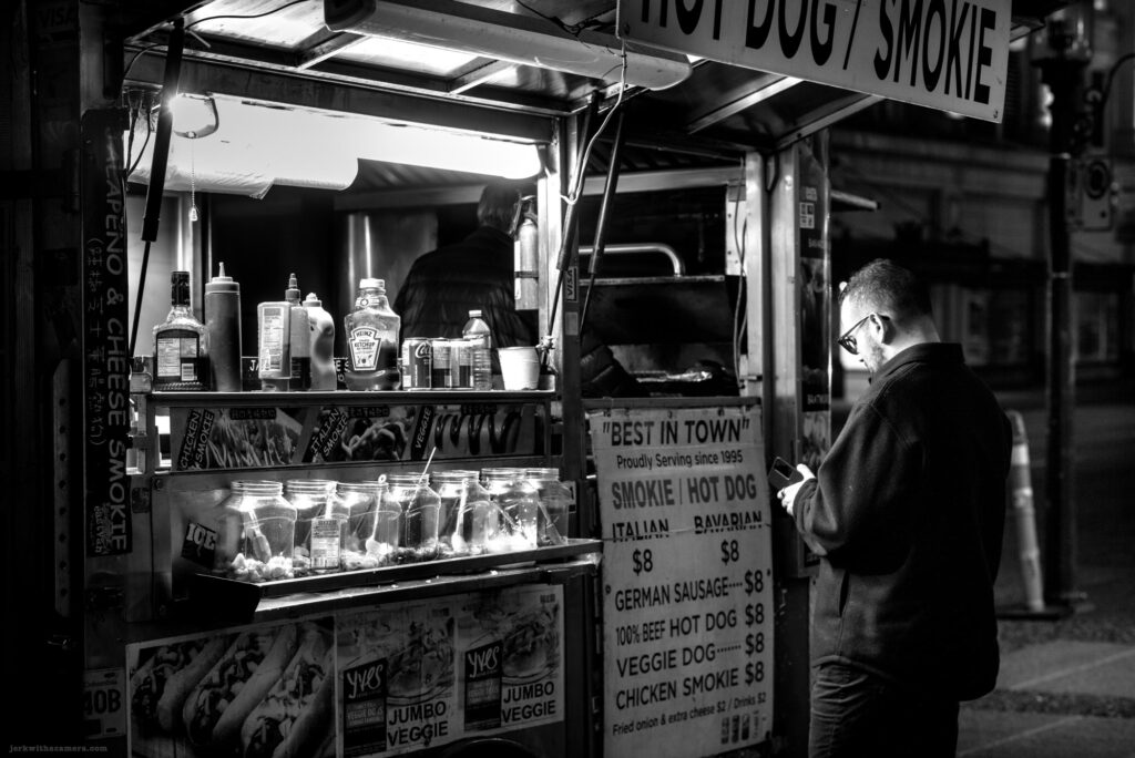 Condiments and jars at a hot dog cart at night