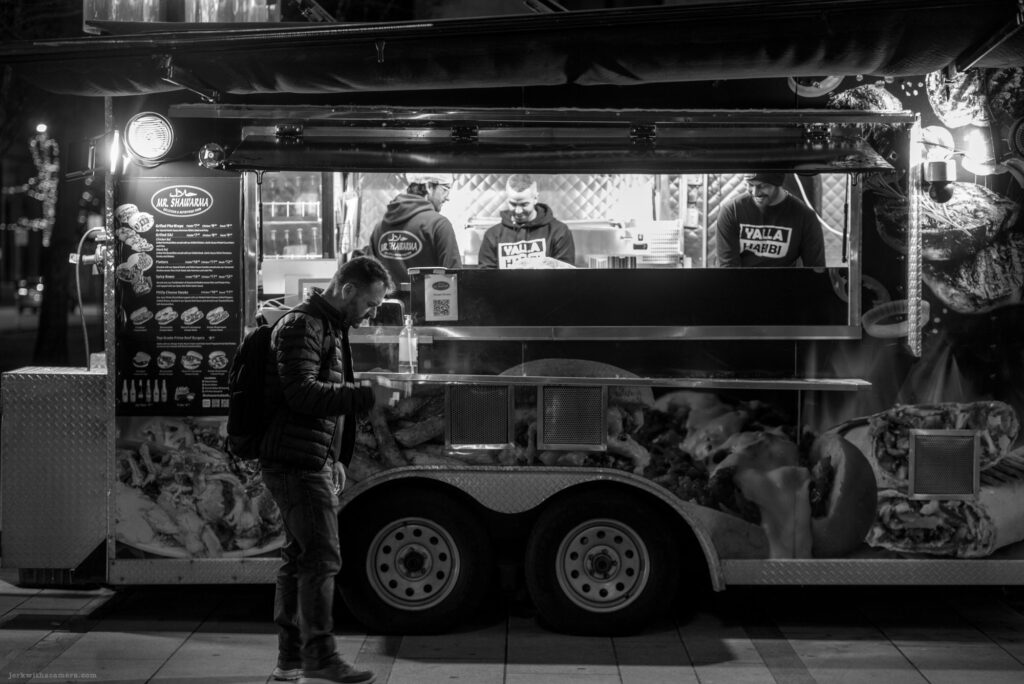 Person waiting at a food truck at night