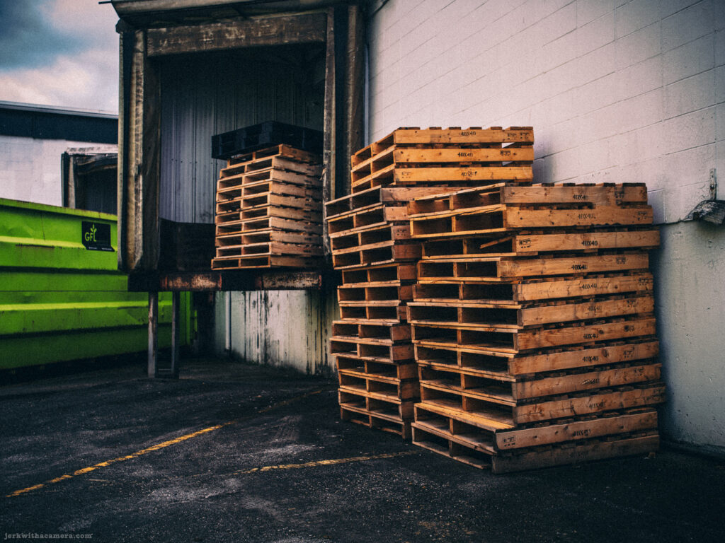 Neatly stacked wooden pallets by a loading bay