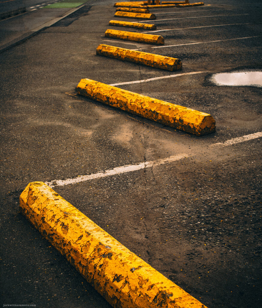 Close-up view of yellow parking curbs in a row
