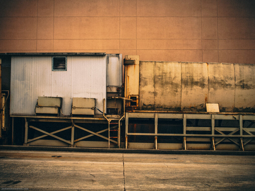 Rusty industrial equipment against a brown wall
