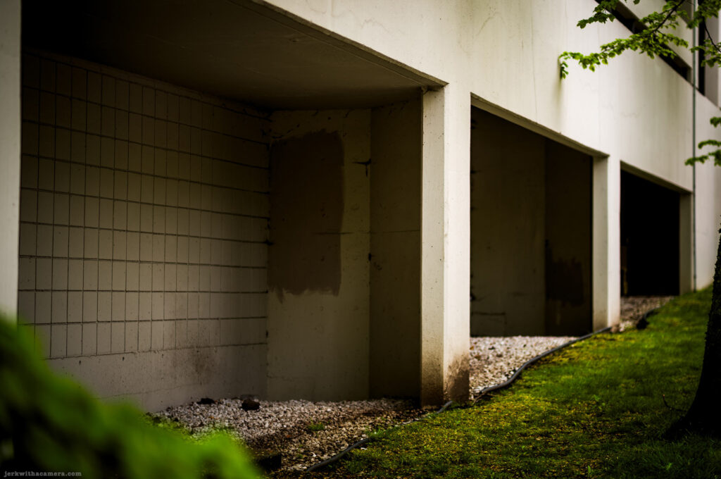 Empty ground-level spaces with tiled and concrete walls