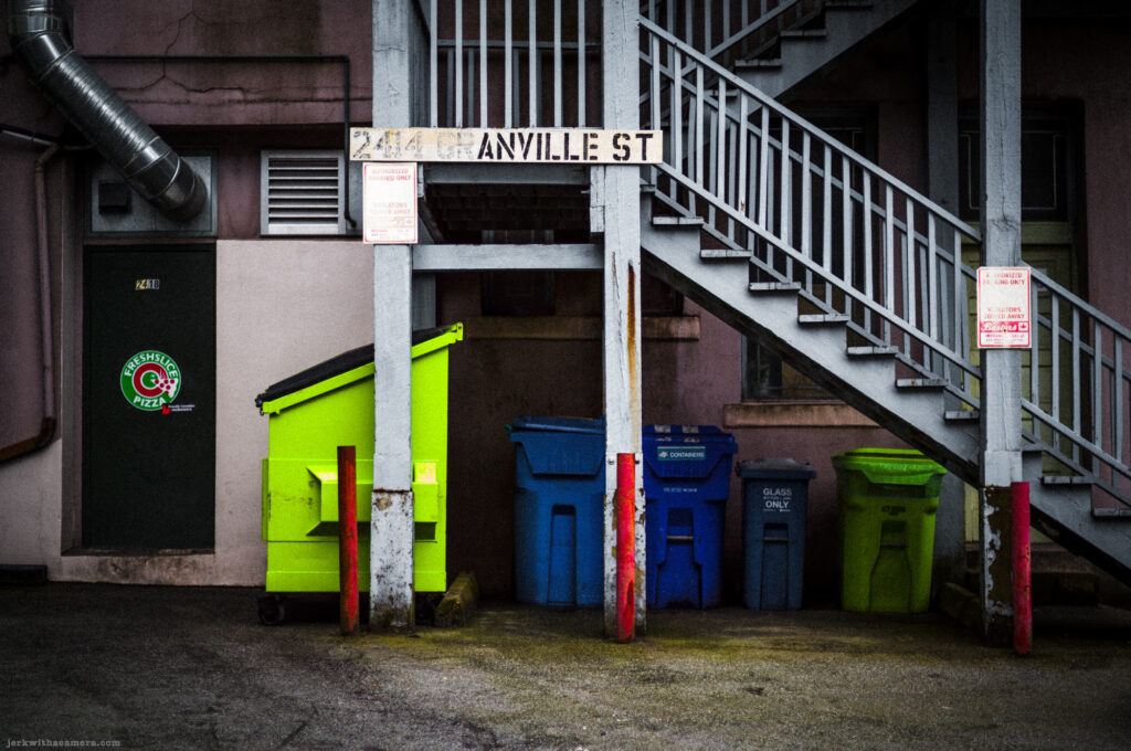 Garbage and recycling bins beneath outdoor staircase