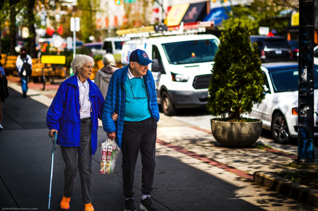 Elderly couple walking together on a city sidewalk in daylight