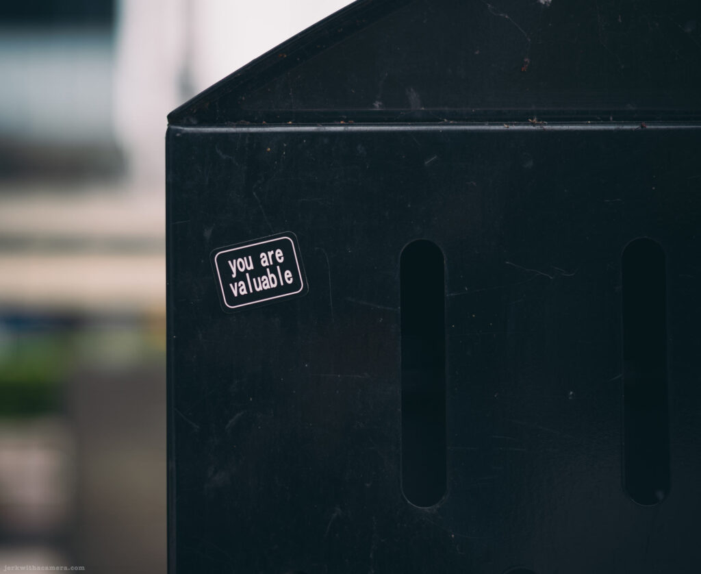 Small sticker on black surface reading “you are valuable”