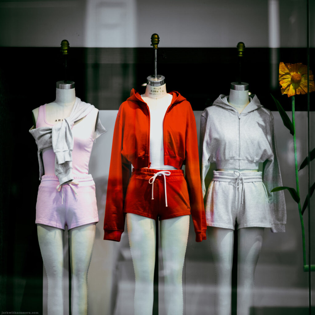 Three mannequins in athletic wear behind a glass window