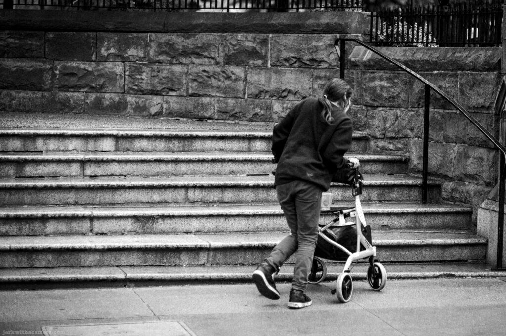 Person with a walker climbing a stone staircase