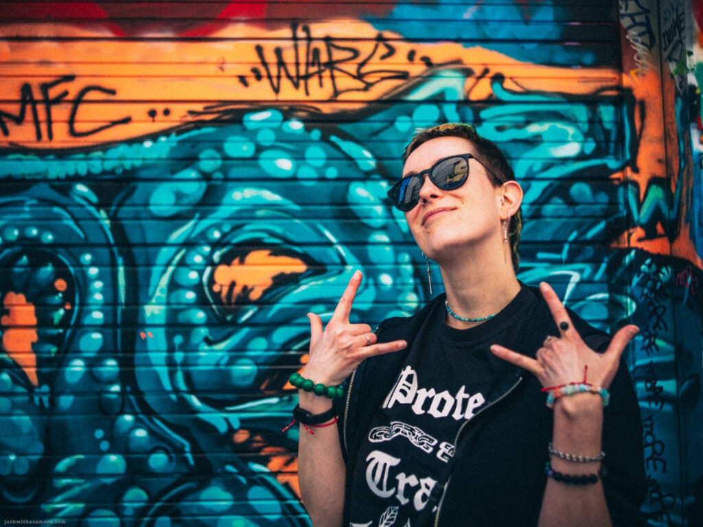 Kay standing in front of a graffiti-covered garage door