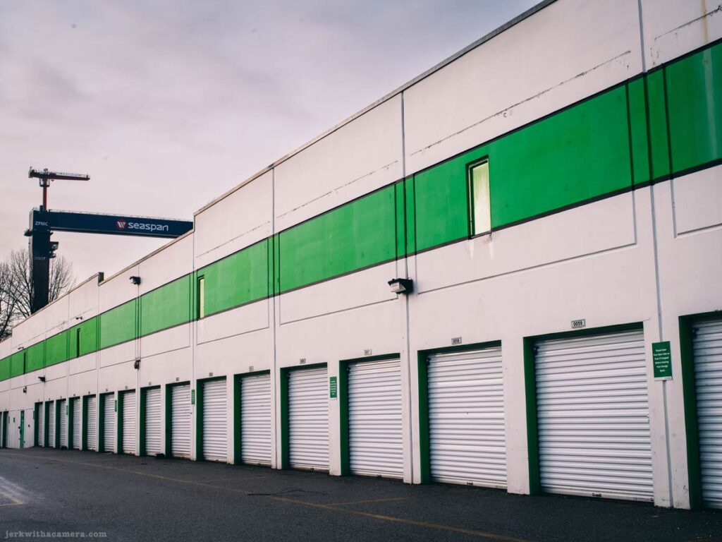 Row of storage unit doors with green stripe on industrial building in North Vancouver