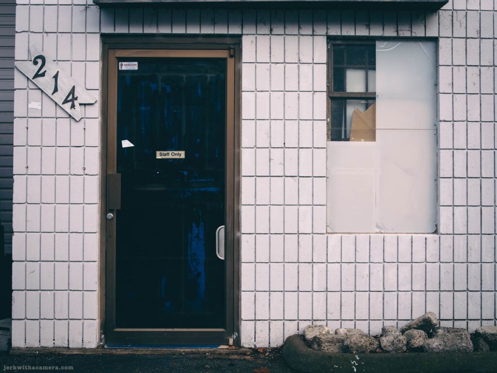 Industrial exterior door with address number 214 on a tiled wall at Lonsdale Quay in North Vancouver
