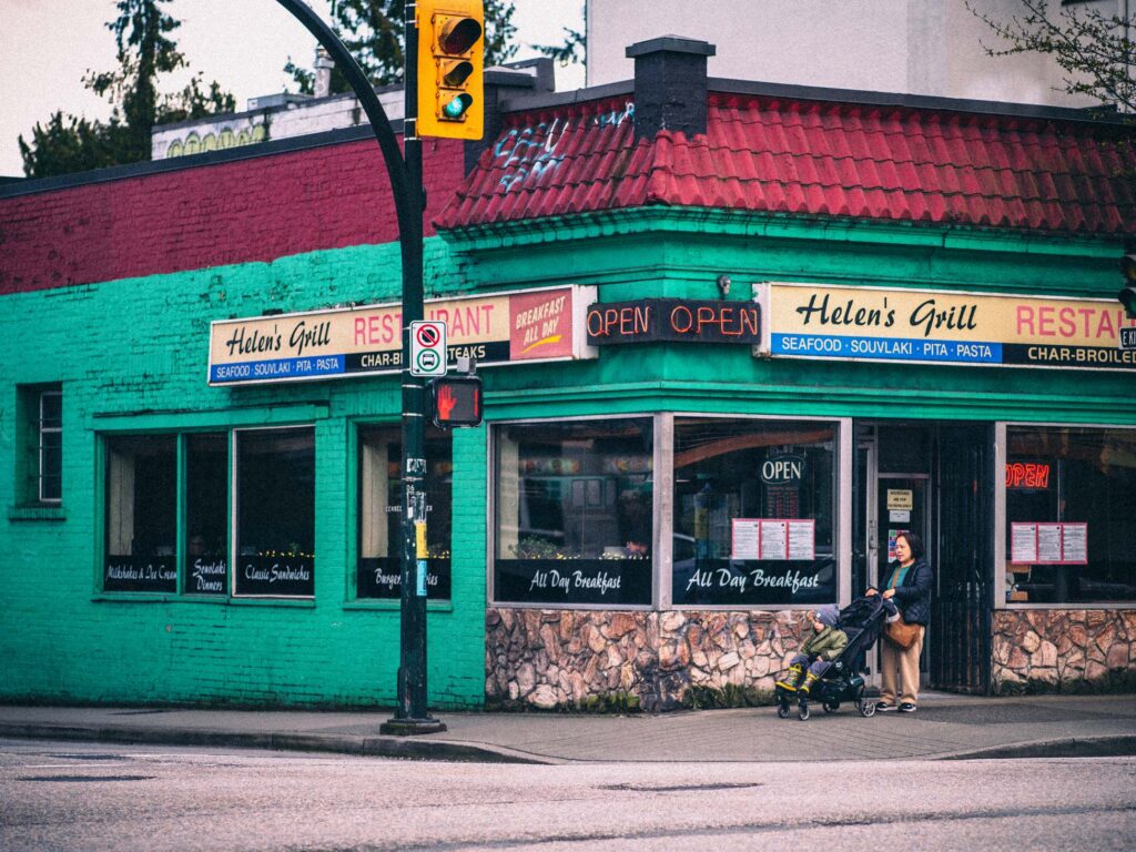 Helen’s Grill restaurant exterior with teal walls and neon open signs