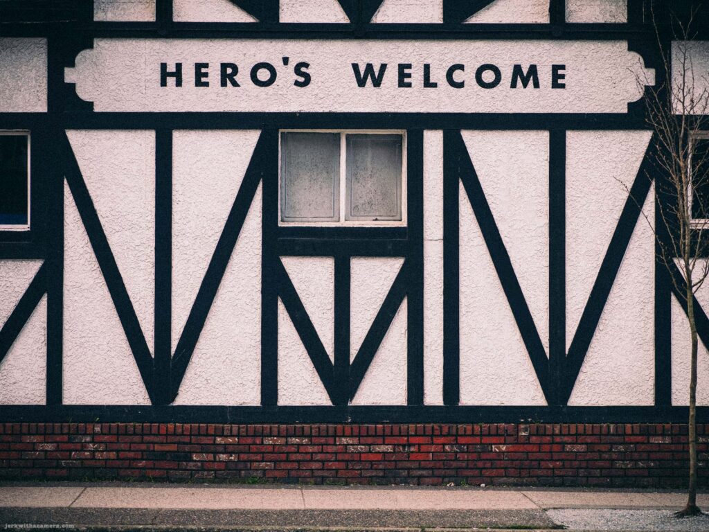 Black and white Tudor-style building facade with “Hero’s Welcome” sign
