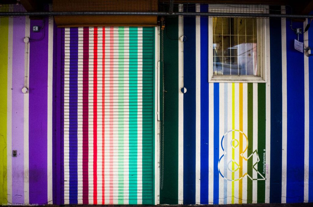 Colourful striped garage door and painted wall with vertical lines