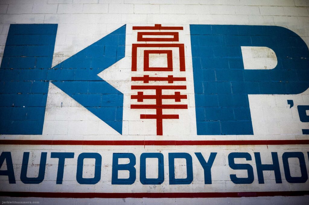 K P Auto Body Shop sign painted on a wall