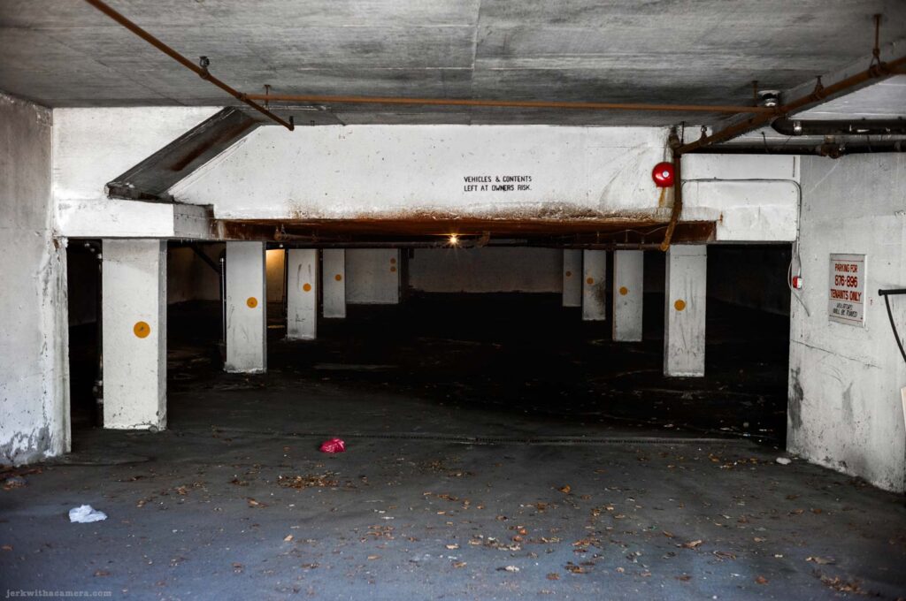 Underground parking garage with concrete column and pipe on Commercial Drive in Vancouver