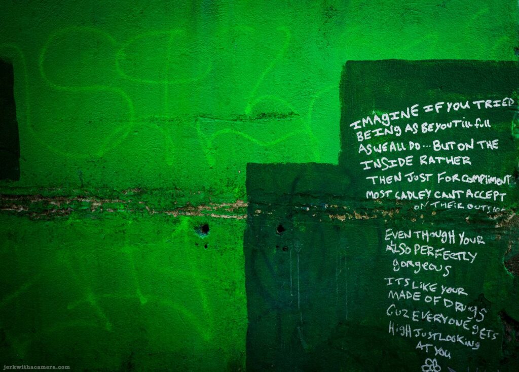 Handwritten graffiti message on a green painted wall