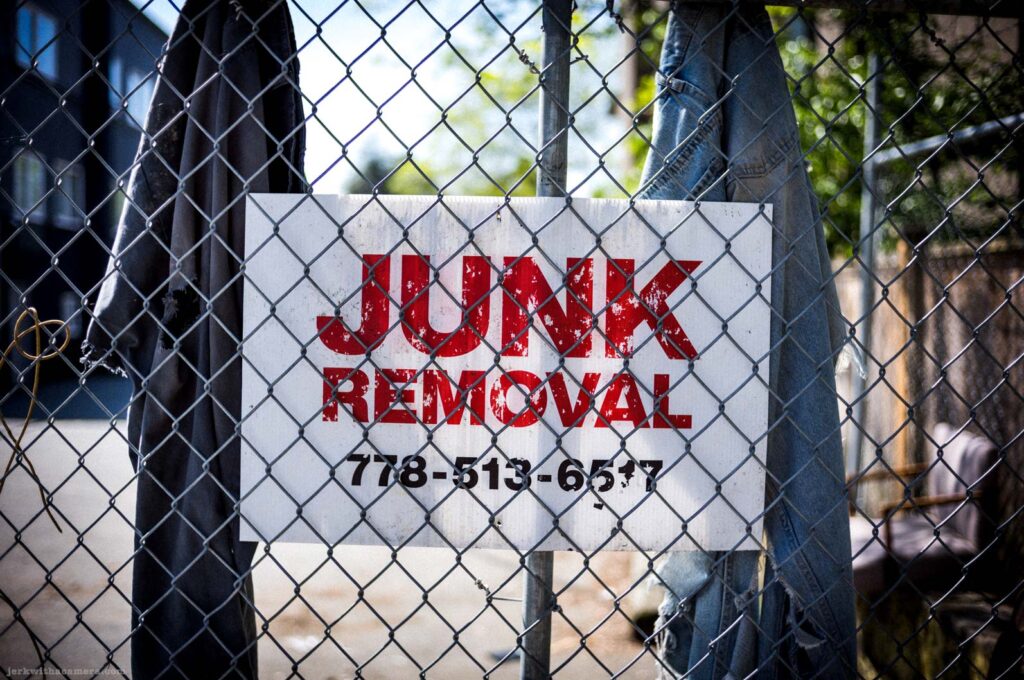 Junk removal sign behind a chain link fence