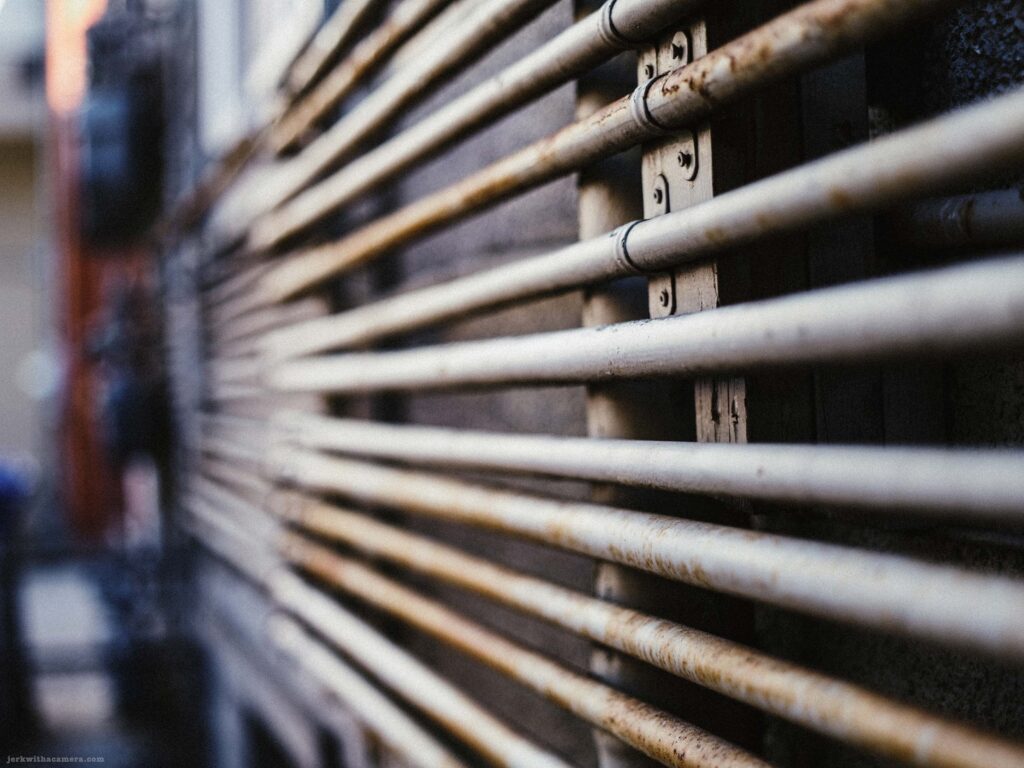 Gas meters and utility lines attached to the side of a building.